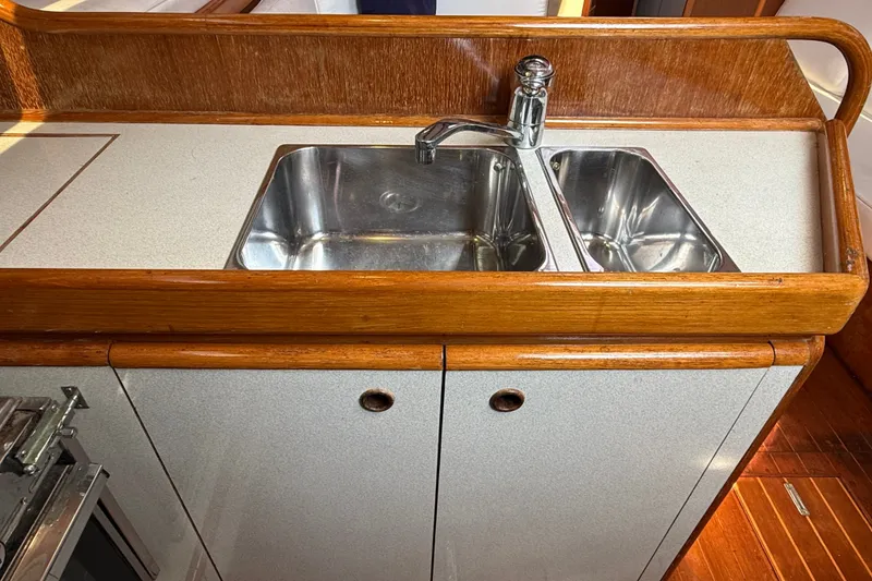 Slide: The Image of Galley sink in 1988 Belliure 41 yacht with dual basins and wooden trim. - 36