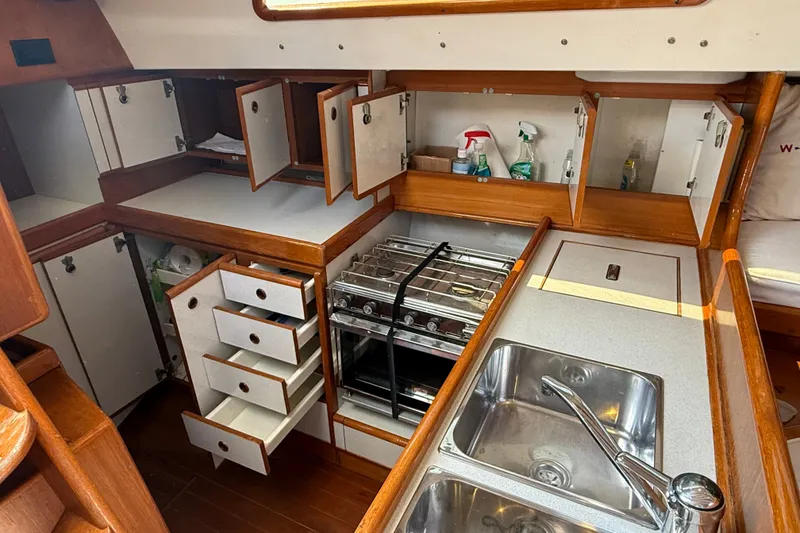 Slide: The Image of 1988 Belliure 41 yacht kitchen with wooden cabinets, stove, and stainless steel sink. - 33