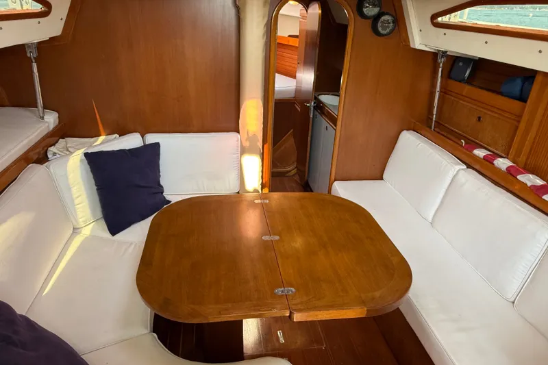 Slide: The Image of Cozy interior of 1988 Belliure 41 yacht with wooden table and white seating. - 14