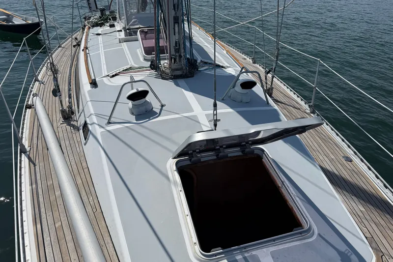 Slide: The Image of 1988 Belliure 41 sailboat deck with open hatch, docked on calm water. - 55