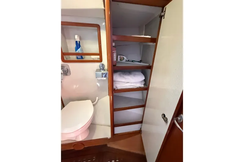 Slide: The Image of 1988 Belliure 41 yacht bathroom with toilet, shelves, and toiletries. - 49