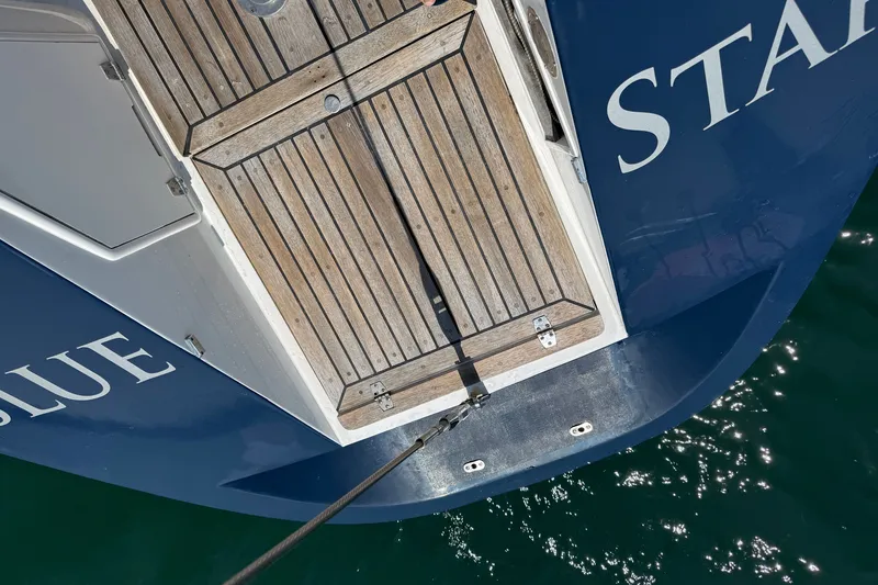 Slide: The Image of Aerial view of 1988 Belliure 41 yacht stern with wooden deck and blue hull. - 80