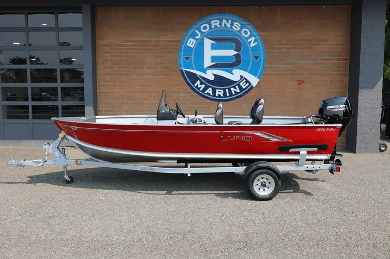 The Image of 2027 Lund 1600 Fury SS in bright red on a trailer in front of a brick building. - 1
