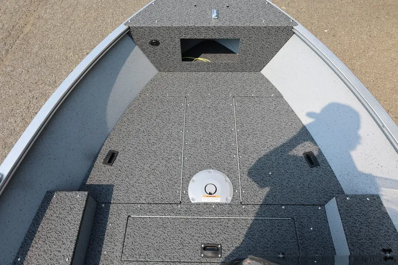 Slide: The Image of The image shows the deck of a Lund 1600 Fury SS boat with gray carpeting. - 7