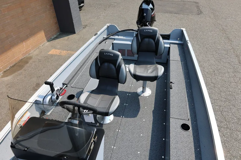 Slide: The Image of Lund 1600 Fury SS 2027: Two padded seats, steering console, outboard motor, gray flooring. - 18