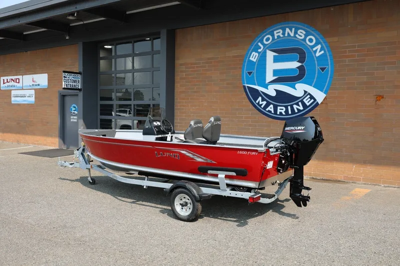 Slide: The Image of A red 2027 Lund 1600 Fury SS boat on a trailer in front of a building with Bjornson Marine logo. - 3