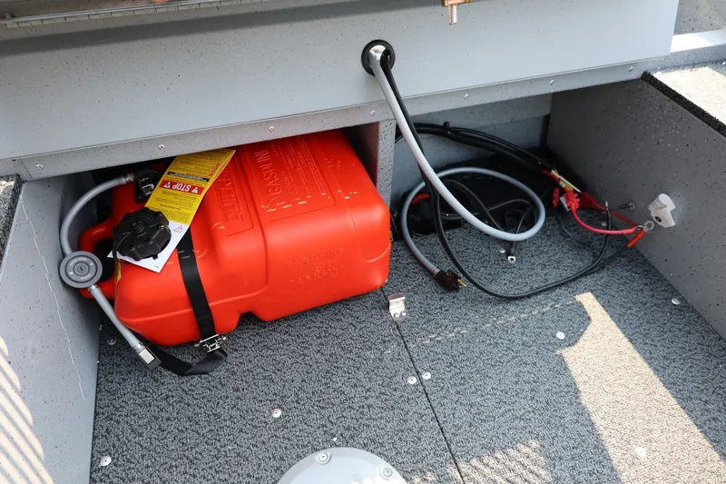 Slide: The Image of A red fuel tank and cables are in a gray storage compartment of a boat. - 21