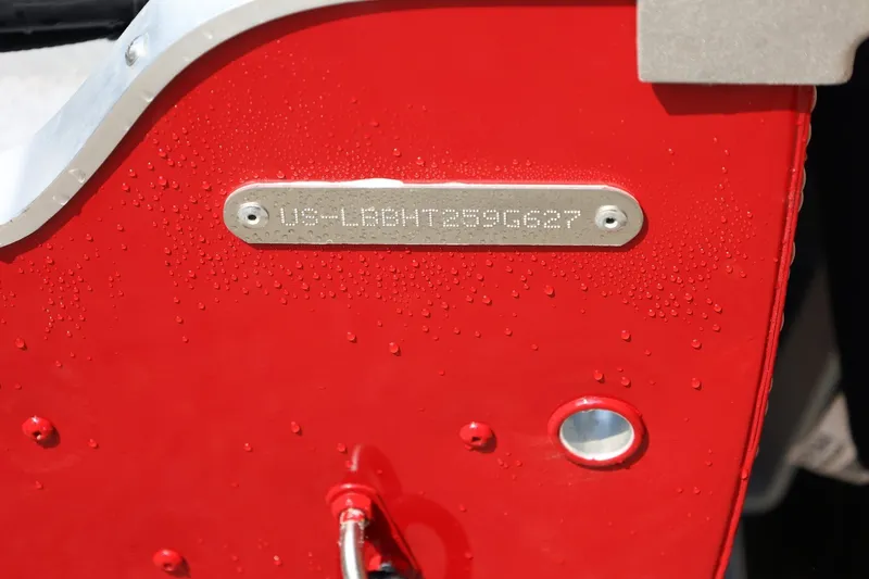 Slide: The Image of Close-up of a red boat hull with a serial number on a metal plate. - 24