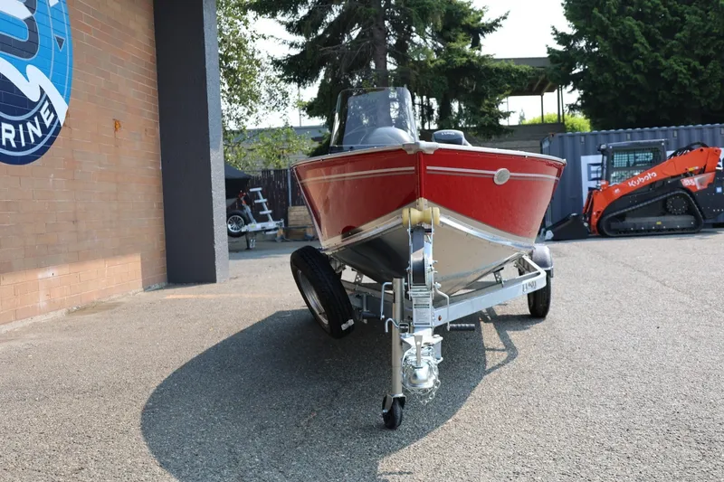 Slide: The Image of Red boat on a trailer in front of a building, with trees in the background. - 30