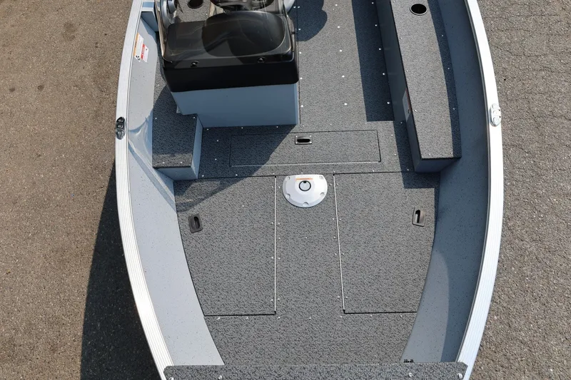 Slide: The Image of Lund 1600 Fury SS 2027: Spacious deck with gray carpeting, bench seat, and steering console. - 6