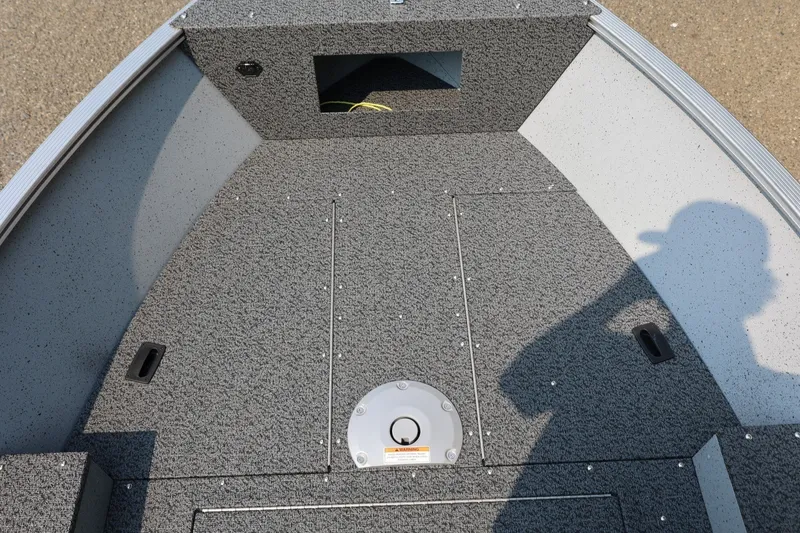 Slide: The Image of The image shows the deck of a Lund 1600 Fury SS boat with gray carpeting. - 9