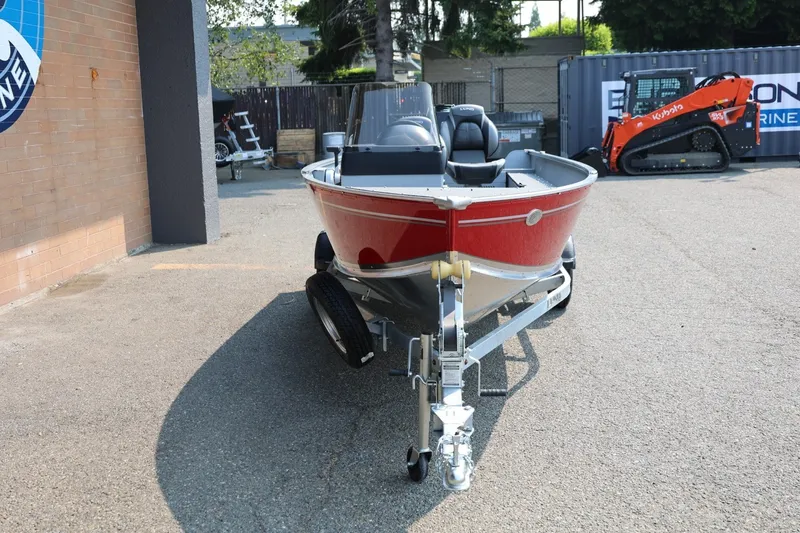 Slide: The Image of Lund 1600 Fury SS 2027: Red aluminum boat on a trailer, parked on a concrete lot. - 29