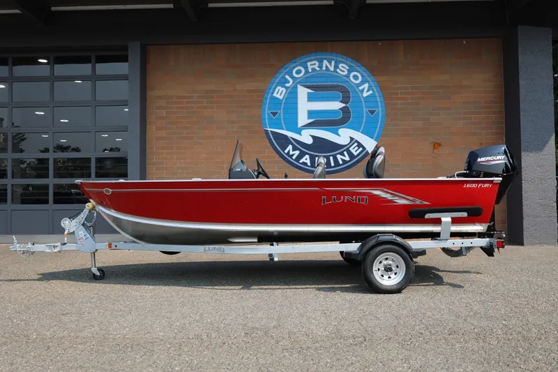 Slide: The Image of 2027 Lund 1600 Fury SS in front of a building with Bjornson Marine logo. - 2