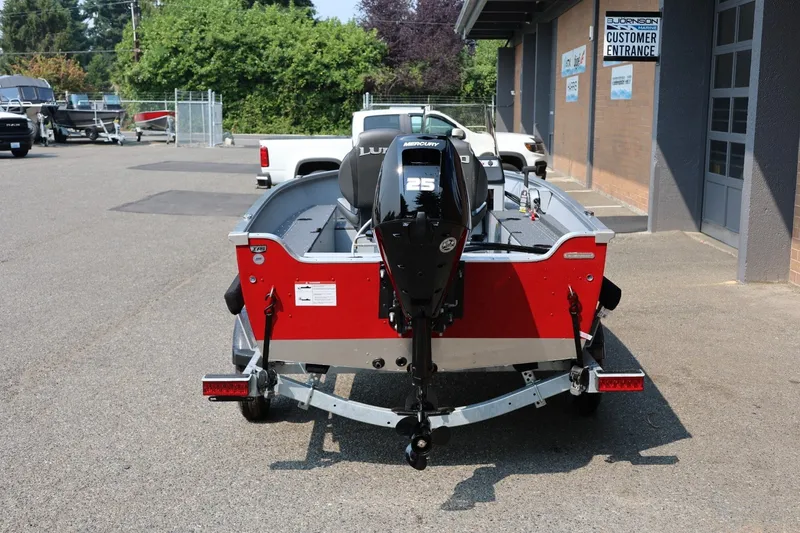 Slide: The Image of A red 2027 Lund 1600 Fury SS boat on a trailer. It features a 25 HP motor. - 5