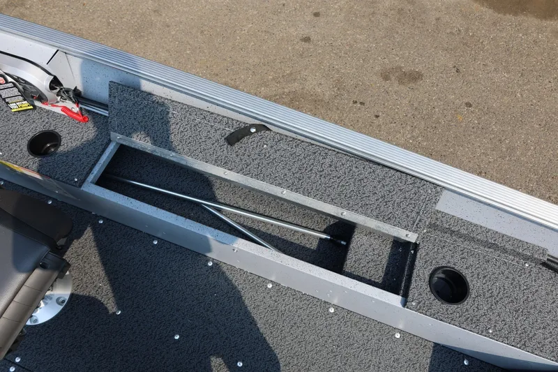 Slide: The Image of The image shows the interior of a 2027 Lund 1600 Fury SS boat with gray carpeting. - 13