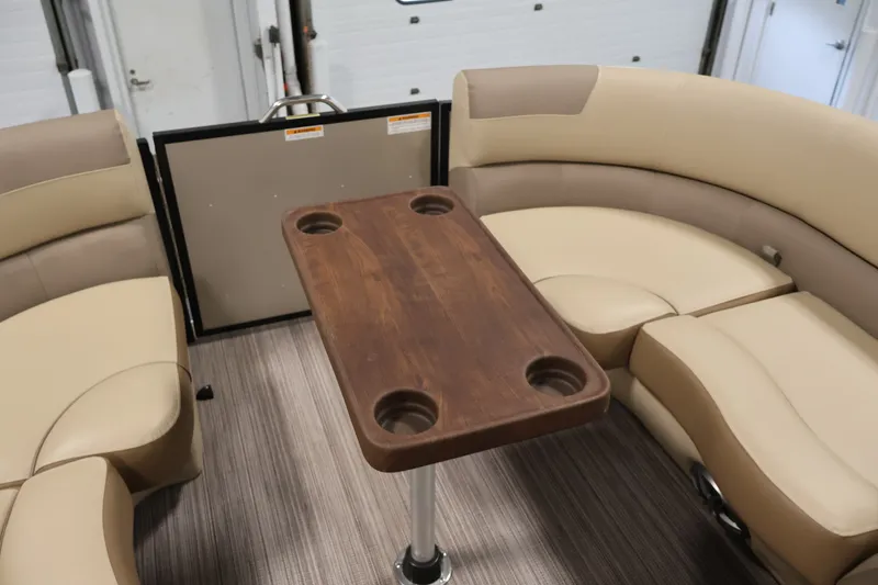 Slide: The Image of 2022 Veranda VR22RC interior with beige seating and wooden table featuring cup holders. - 16