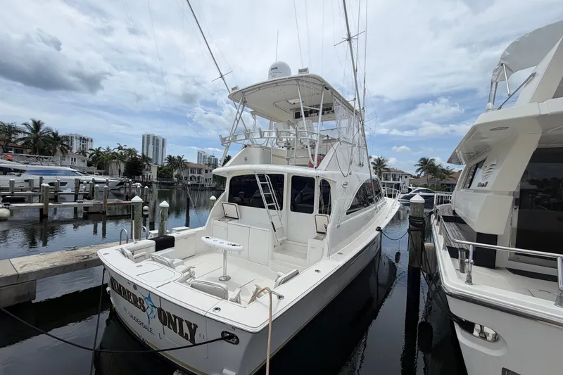 Slide: The Image of 2001 Ocean Yachts 56 Super Sport docked at marina under cloudy sky. - 2