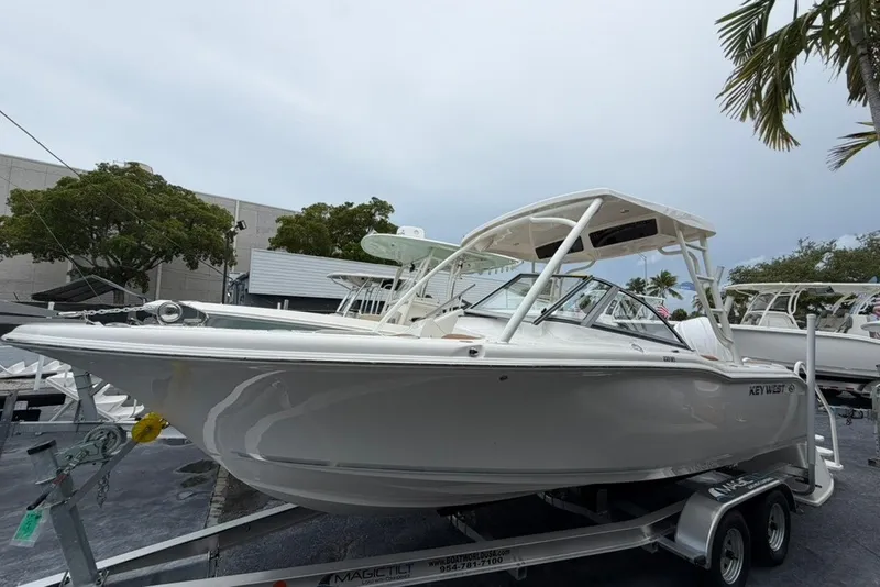 The Image of 2027 Key West 239 DFS boat on trailer, displayed outdoors with trees in background. - 1