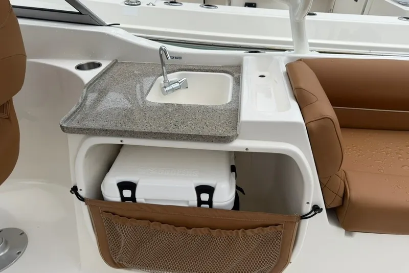 Slide: The Image of 2027 Key West 239 DFS boat interior with sink, cooler, and brown seating. - 21