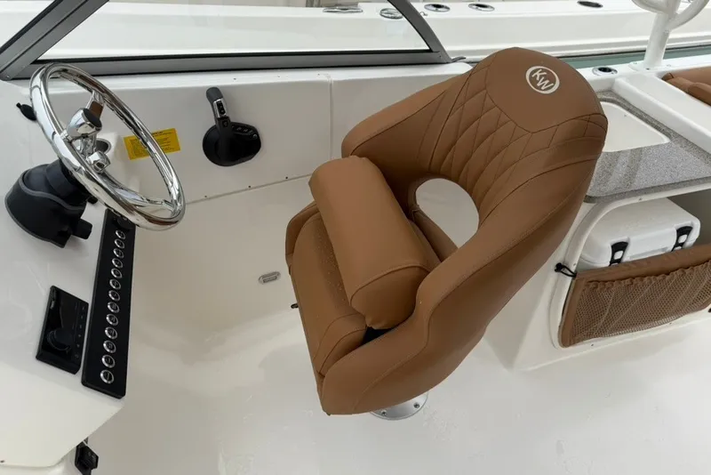 Slide: The Image of 2027 Key West 239 DFS boat interior with brown captain's chair and steering wheel. - 14