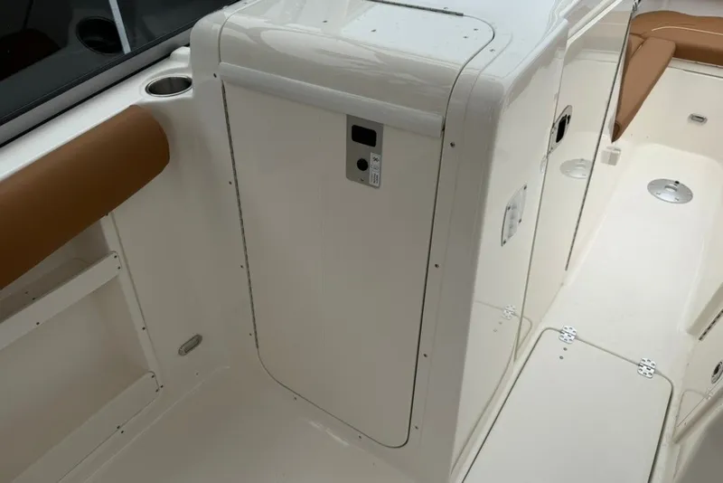 Slide: The Image of 2027 Key West 239 DFS boat interior with white and brown seating, cup holder, and storage compartment. - 39