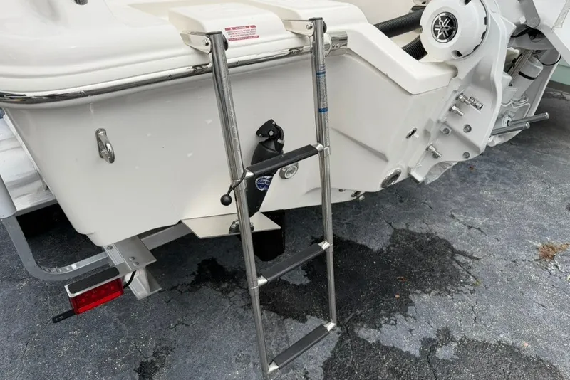 Slide: The Image of Rear view of 2027 Key West 239 DFS boat with ladder and motor details. - 49