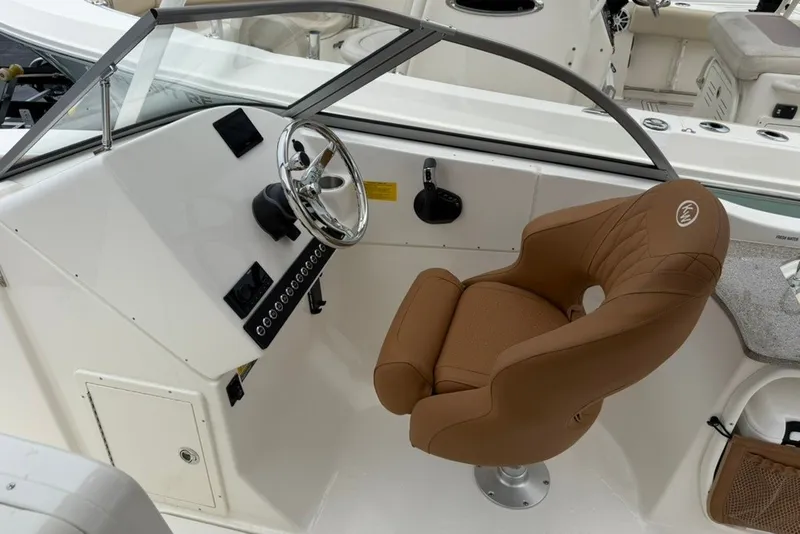 Slide: The Image of 2027 Key West 239 DFS boat cockpit with brown captain's chair and steering wheel. - 13