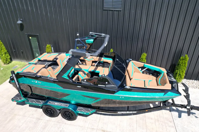 Slide: The Image of 2027 Tigé 22RZX boat with teal and tan interior, parked on a trailer. - 16
