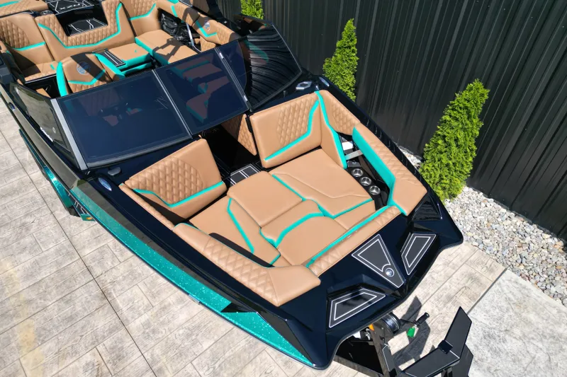 Slide: The Image of 2027 Tigé 22RZX boat with luxurious tan and teal interior, docked outdoors. - 6