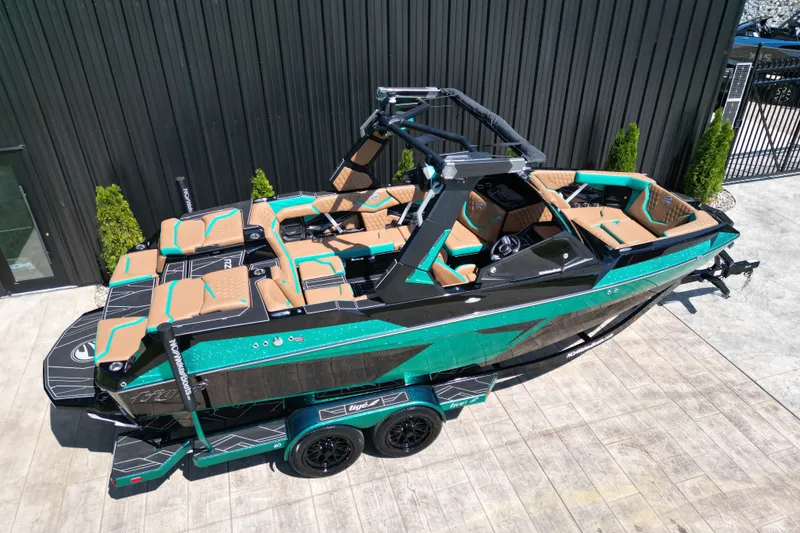 Slide: The Image of 2027 Tigé 22RZX boat with teal and tan interior, parked on a trailer. - 4