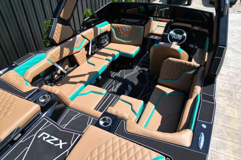 Slide: The Image of Luxurious interior of 2027 Tigé 22RZX boat with tan and teal seating. - 14