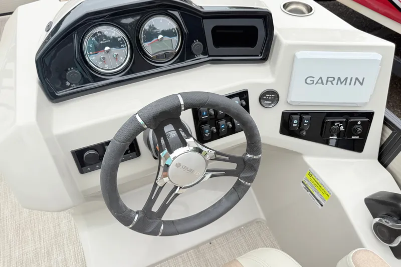 Slide: The Image of 2027 Manitou Aurora SE 21 boat dashboard with Garmin navigation system and steering wheel. - 10
