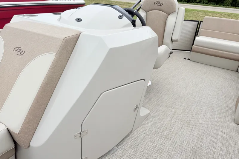 Slide: The Image of 2027 Manitou Aurora SE 21 boat interior with beige seating and helm console. - 8