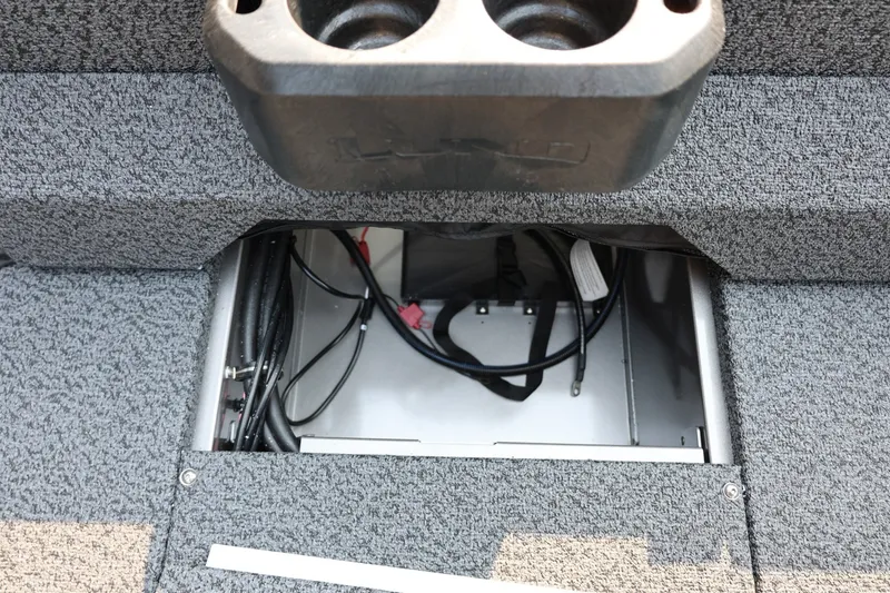 Slide: The Image of Open storage compartment in 2027 Lund 1875 Impact XS Sport boat, showing wiring and cup holder. - 40
