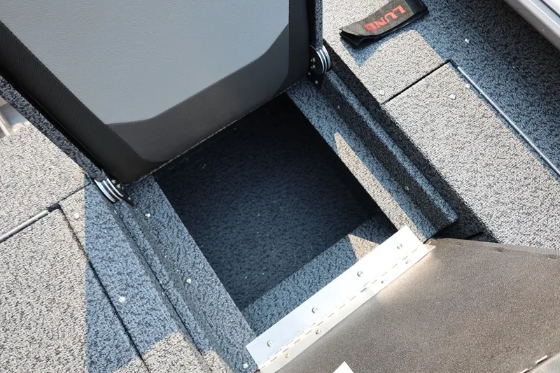 Slide: The Image of Interior storage compartment of 2027 Lund 1875 Impact XS Sport boat, featuring carpeted flooring. - 43