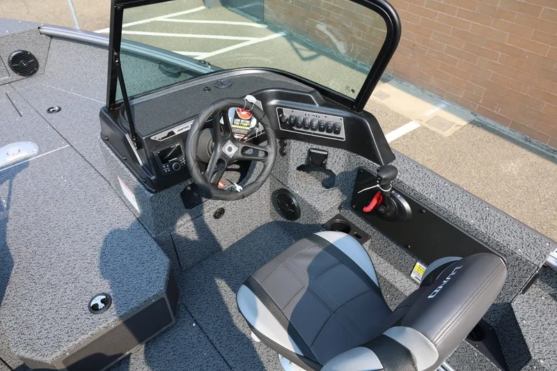 Slide: The Image of 2027 Lund 1875 Impact XS Sport boat interior with steering wheel and controls. - 24