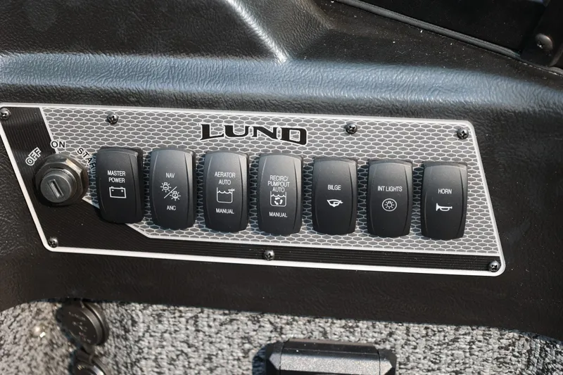 Slide: The Image of Control panel of 2027 Lund 1875 Impact XS Sport boat with labeled switches. - 25