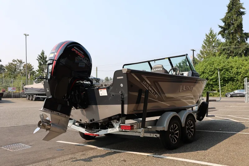 Slide: The Image of 2027 Lund 1875 Impact XS Sport boat on trailer, featuring powerful outboard motor. - 8
