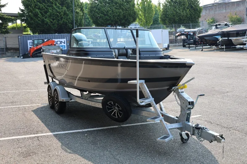 Slide: The Image of 2027 Lund 1875 Impact XS Sport boat on trailer in parking lot. - 9