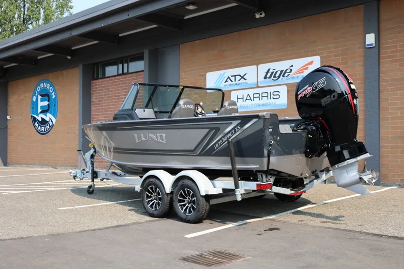 Slide: The Image of 2027 Lund 1875 Impact XS Sport boat on trailer outside marine dealership. - 4