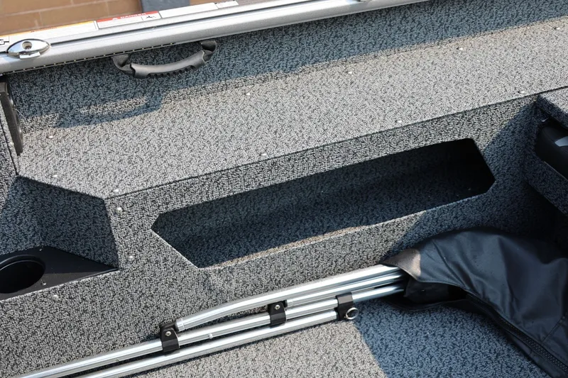 Slide: The Image of Interior of 2027 Lund 1875 Impact XS Sport boat, featuring storage compartments and carpeted flooring. - 36