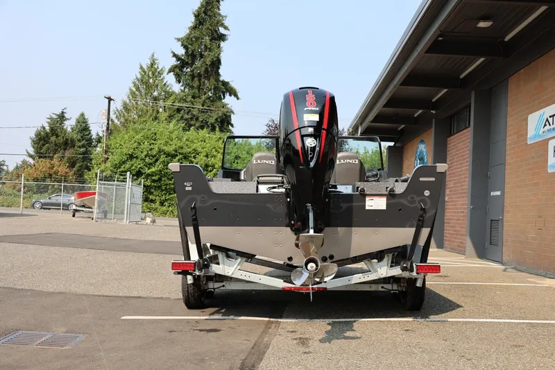 Slide: The Image of 2027 Lund 1875 Impact XS Sport boat with outboard motor in parking lot. - 6