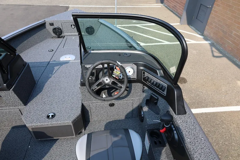 Slide: The Image of 2027 Lund 1875 Impact XS Sport boat interior with steering wheel and dashboard controls. - 26