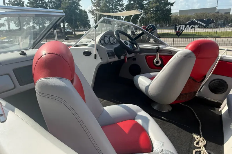 Slide: The Image of 2006 Skeeter SL 190 boat interior with red and gray seating, steering wheel, and dashboard. - 11