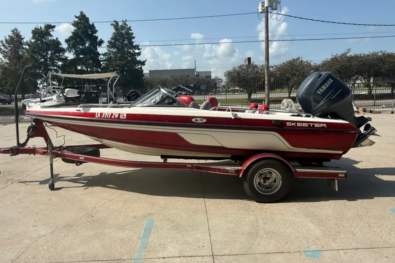 Slide: The Image of 2006 Skeeter SL 190 boat on trailer with Yamaha outboard motor, parked outdoors. - 6