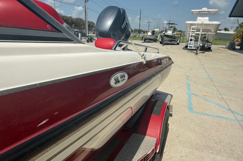 Slide: The Image of 2006 Skeeter SL 190 boat in a parking lot, featuring a red and white design. - 9