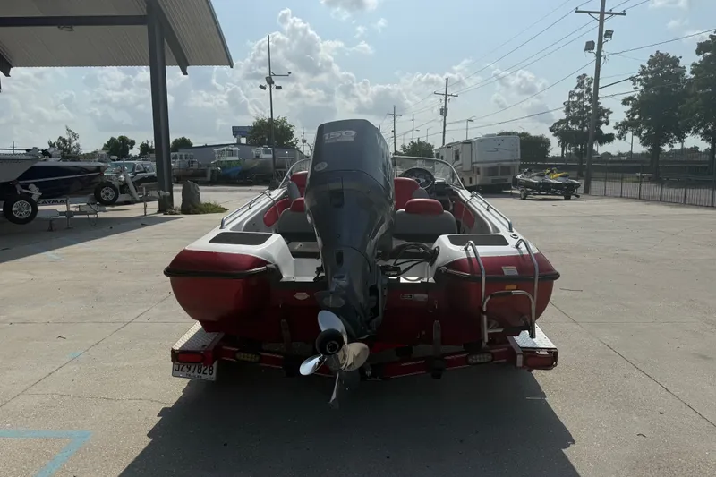 Slide: The Image of 2006 Skeeter SL 190 boat with outboard motor, parked outdoors on a sunny day. - 4