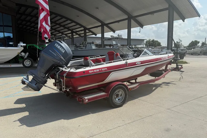 Slide: The Image of 2006 Skeeter SL 190 boat with Yamaha motor on trailer, parked outdoors. - 3