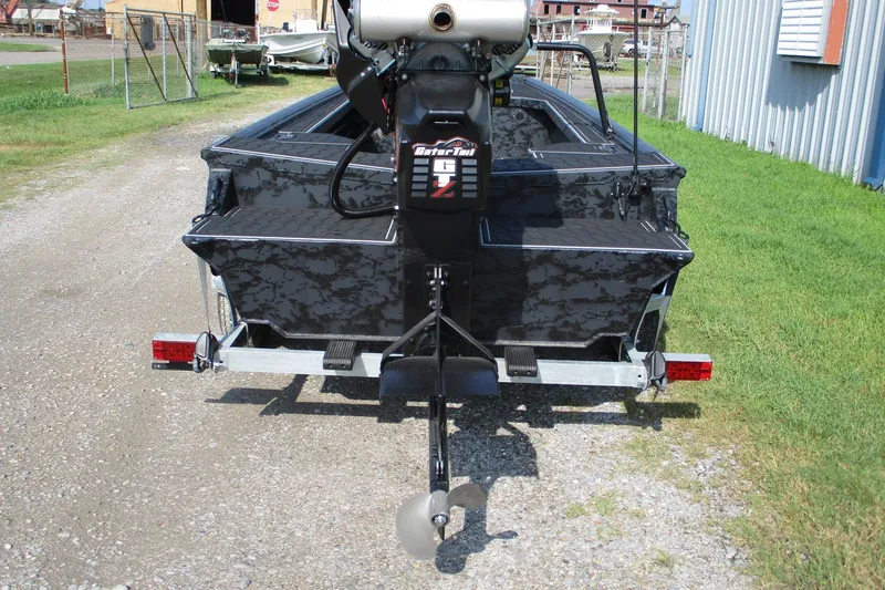 Slide: The Image of 2027 Gatortail 1854 Extreme boat with motor, parked on gravel near a metal building. - 4