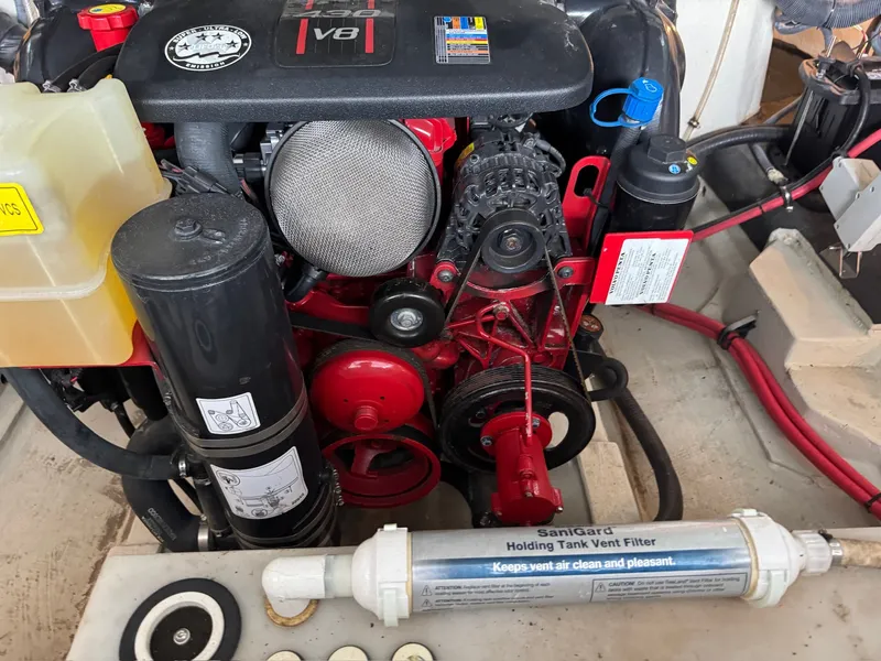 Slide: The Image of An engine compartment with a V8 engine and a SaniGard filter, surrounded by various components. - 28